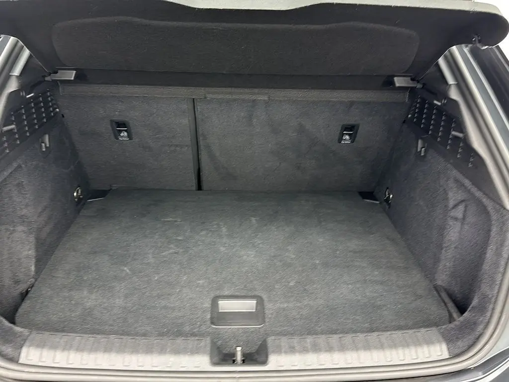 Coffre ouvert vu de l’arrière d’une Audi A3 Sportback 2021 gris Manhattan, espace de chargement propre et spacieux.