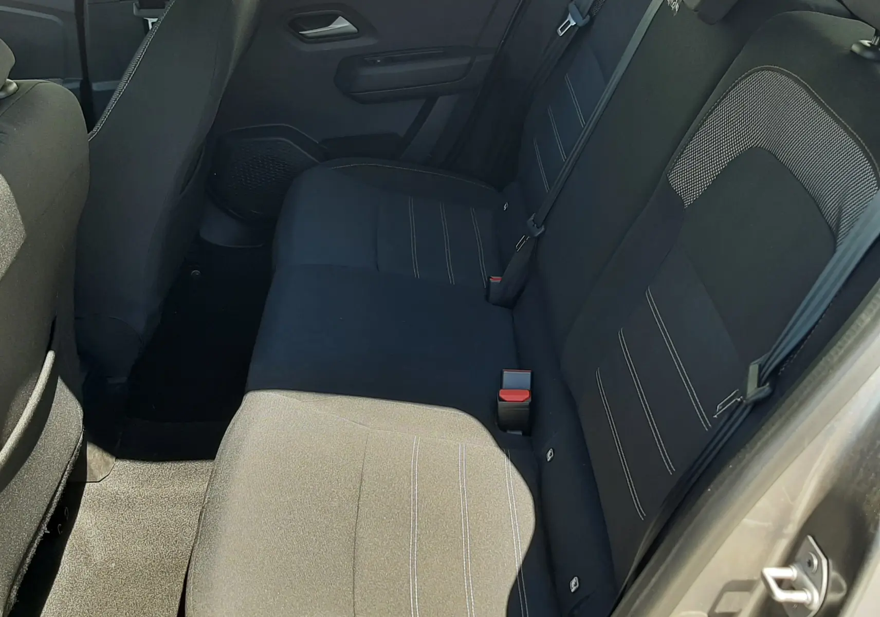 Vue intérieure côté droit des sièges arrière en tissu gris foncé de la Dacia Sandero Stepway 2025, porte ouverte.