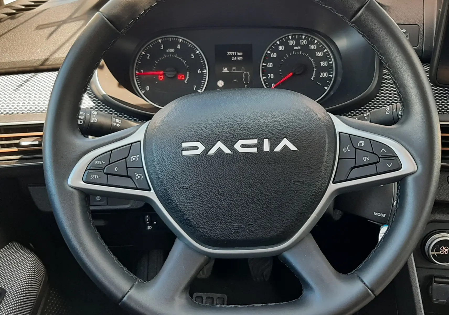 Vue rapprochée du volant noir de la Dacia Sandero Stepway 2025 avec commandes intégrées et tableau de bord visible.