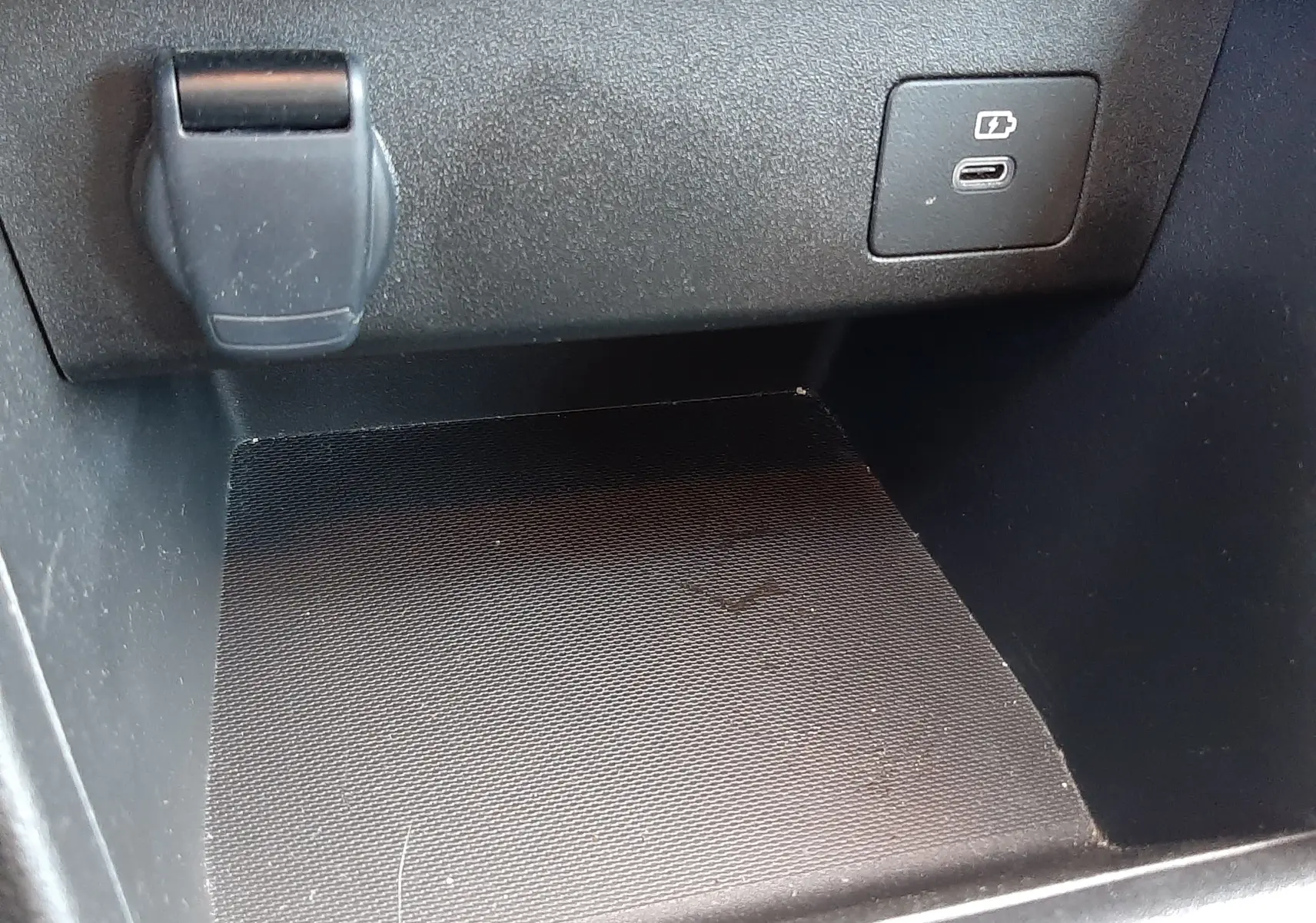 Détail de la console centrale de la Dacia Sandero Stepway 2025, prise de courant et port USB visible sur fond noir.