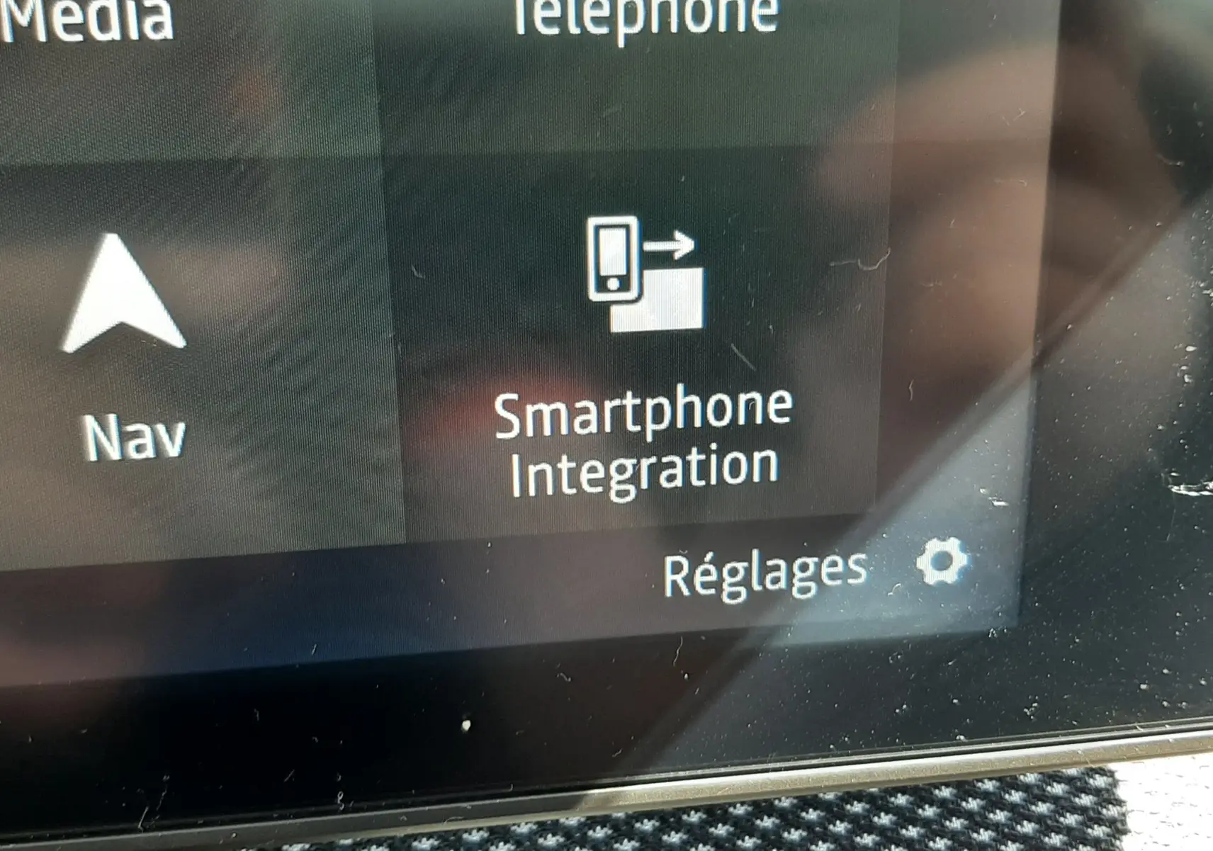 Écran tactile intérieur du Dacia Sandero Stepway 2025 montrant l'option Smartphone Integration avec fond gris et texte blanc.