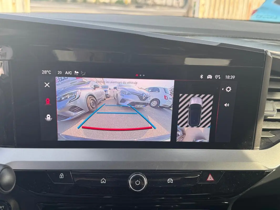 Écran tactile intérieur montrant la caméra de recul avec vue arrière sur une Opel Mokka grise en stationnement.