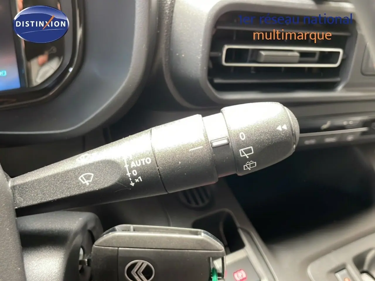 Gros plan sur la commande d’essuie-glace à gauche du volant dans l’habitacle gris foncé du Citroën Berlingo gris Artense 2026.
