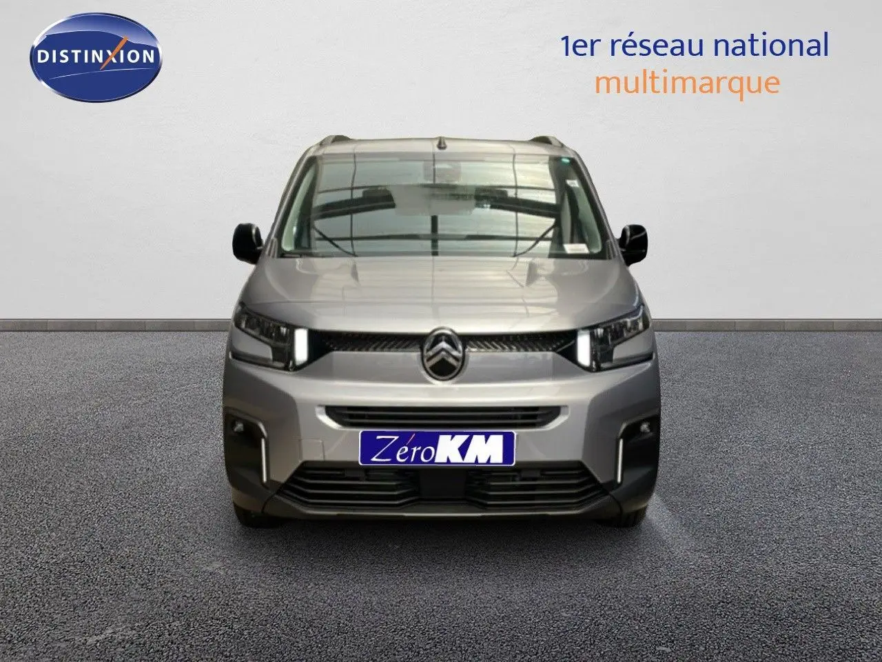 Vue frontale d'un Citroën Berlingo gris Artense métal 2026 avec calandre moderne et phares LED allumés.