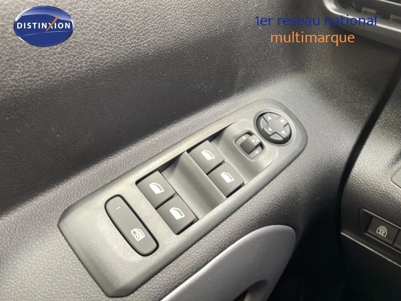 Gros plan sur les commandes de lève-vitres et rétroviseurs côté conducteur du Citroën Berlingo gris 2026.