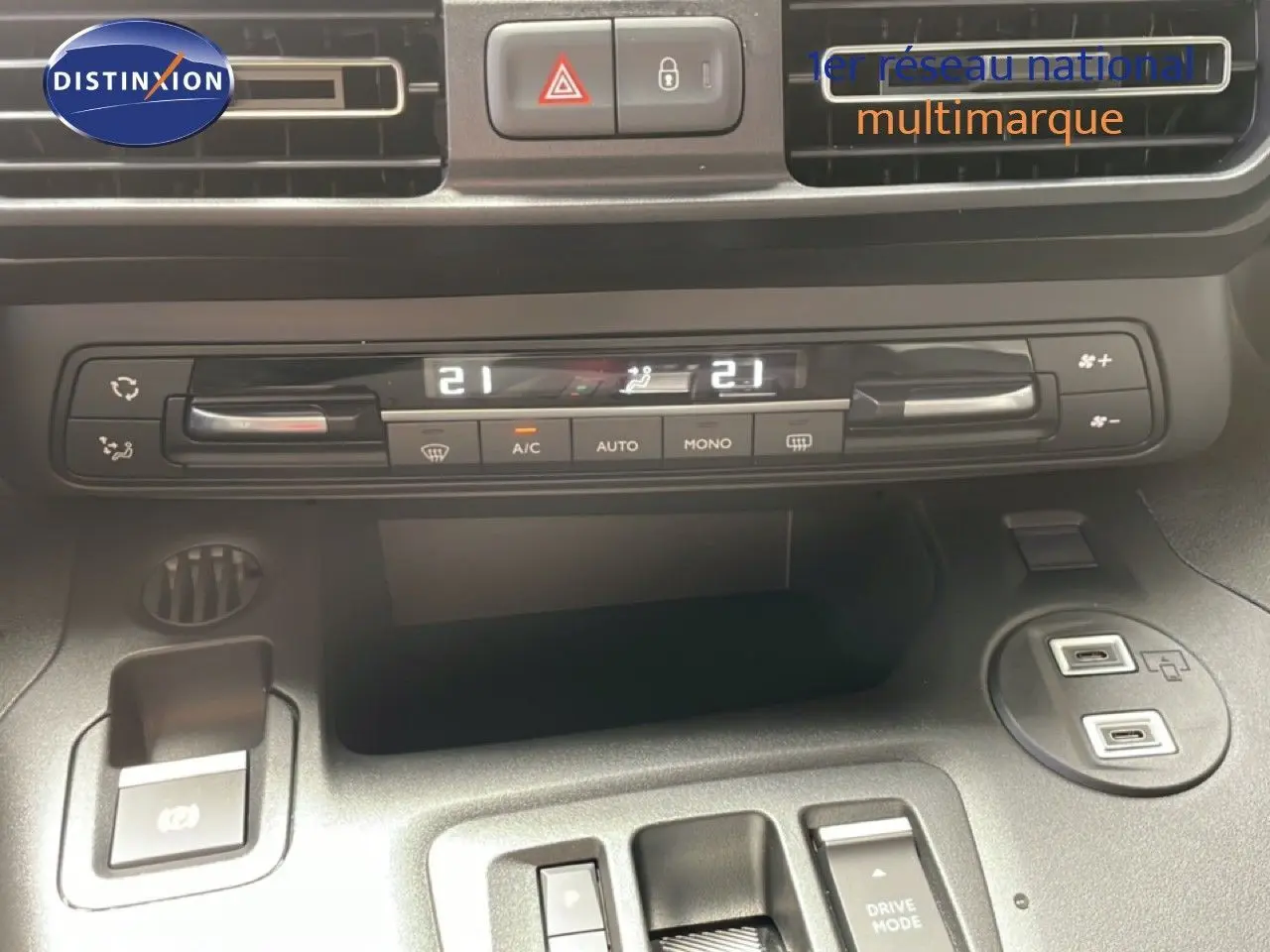 Vue rapprochée du tableau de bord et console centrale du Citroën Berlingo gris, montrant la climatisation digitale et ports USB.