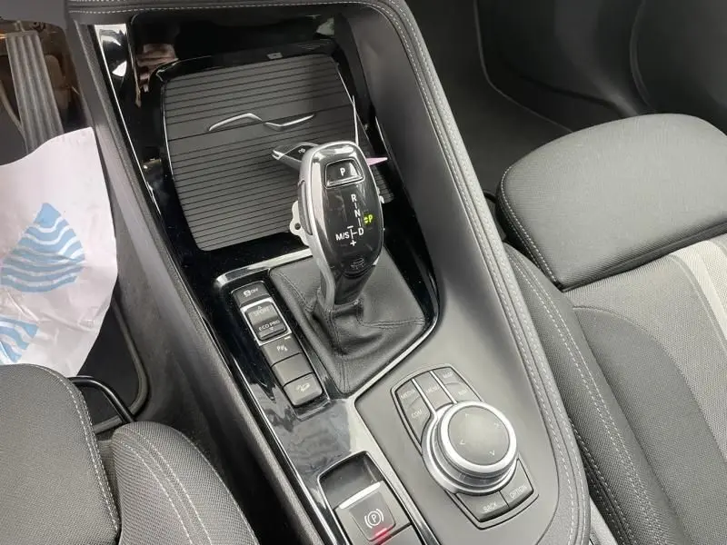 Gros plan sur la console centrale noire brillante avec levier de vitesse automatique du BMW X2 bleu métal 2021.