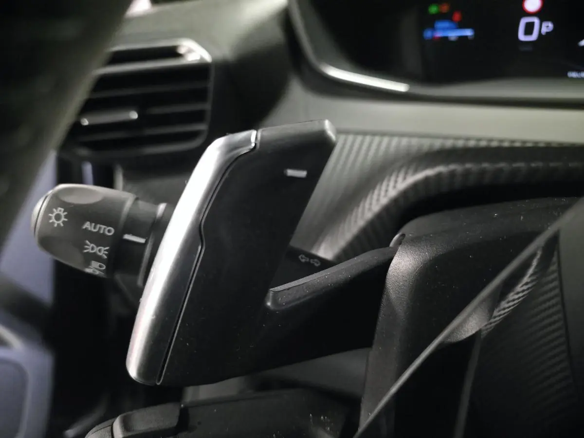 Gros plan sur la palette de commande de boîte automatique noire avec insert argent dans l’habitacle du Peugeot 2008 noir.