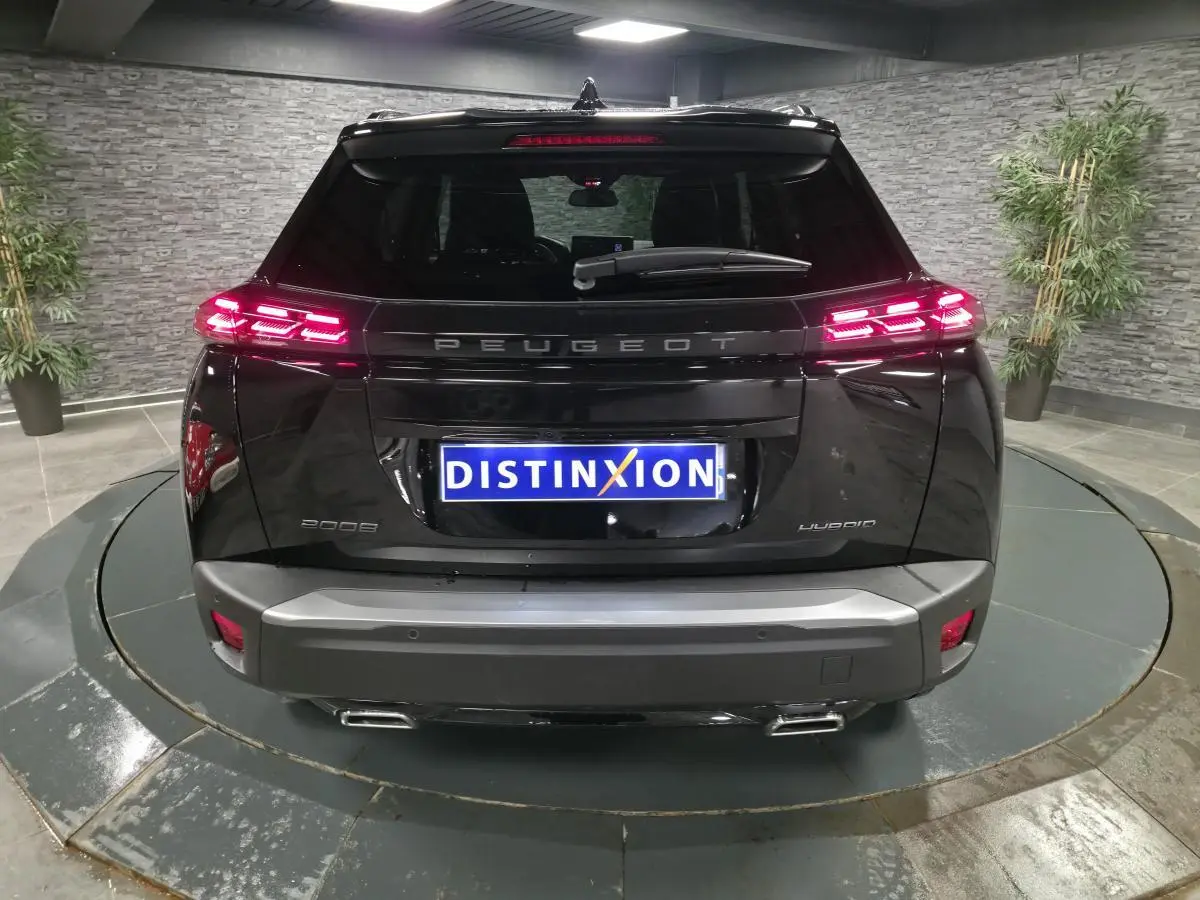 Vue arrière d'un Peugeot 2008 noir avec feux arrière LED allumés et double sortie d'échappement chromée.