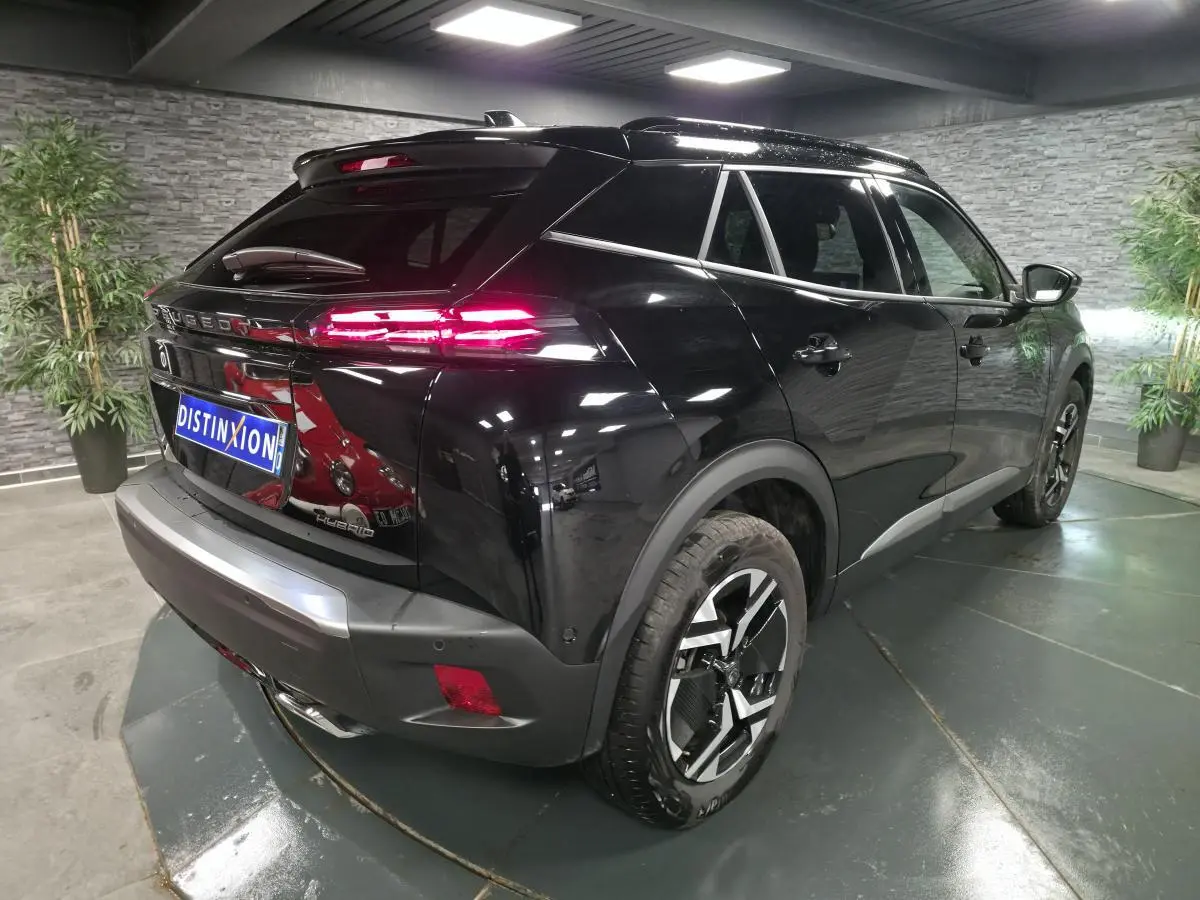 Vue 3/4 arrière droite du Peugeot 2008 noir avec feux arrière LED allumés et jantes alliage bi-ton.