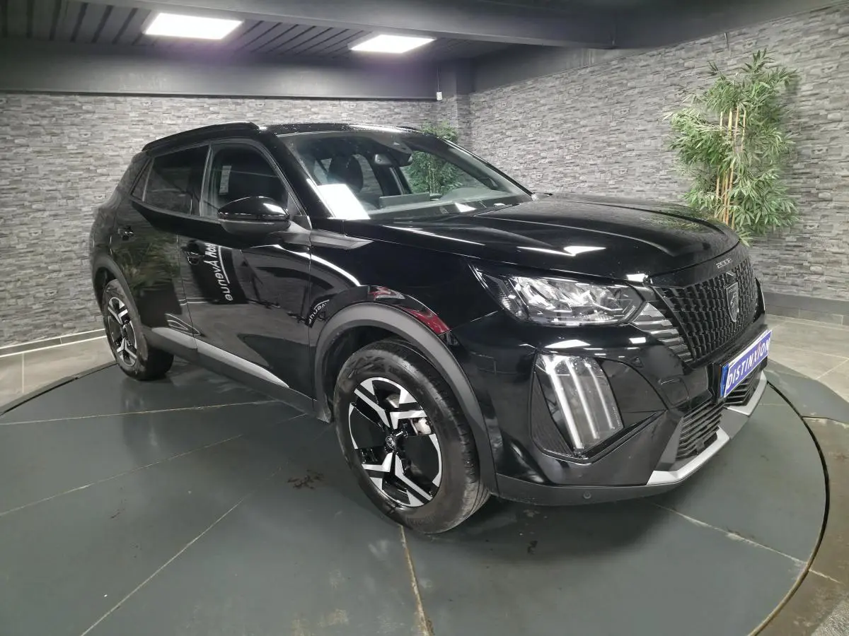 Peugeot 2008 noire vue 3/4 avant droit, avec calandre noire et jantes alliage bi-ton 17 pouces.