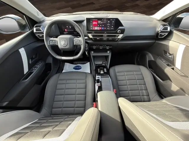 Vue intérieure avant de la Citroën C4 Hybride 2025, montrant le volant cuir multifonctions et l’écran tactile central.