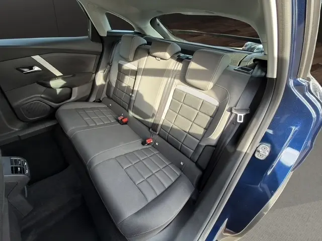 Vue intérieure arrière droite de la banquette tissu gris foncé dans une Citroën C4 hybride bleu 2025.