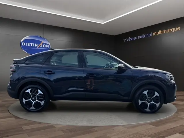 Vue latérale droite d'une Citroën C4 hybride bleu foncé avec jantes distinctives et silhouette SUV coupé.