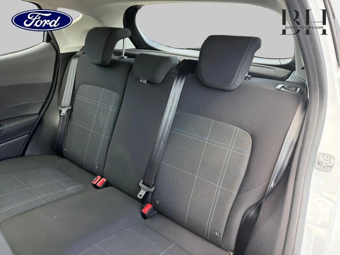 Vue intérieure de la banquette arrière côté droit de la Ford Fiesta blanc glacier avec tissu noir à motifs carreaux.