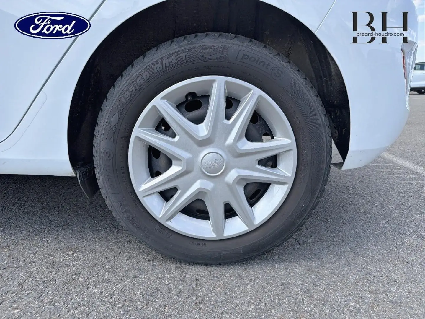 Gros plan sur la roue arrière droite d'une Ford Fiesta blanche Glacier avec enjoliveur d'origine et pneu noir.