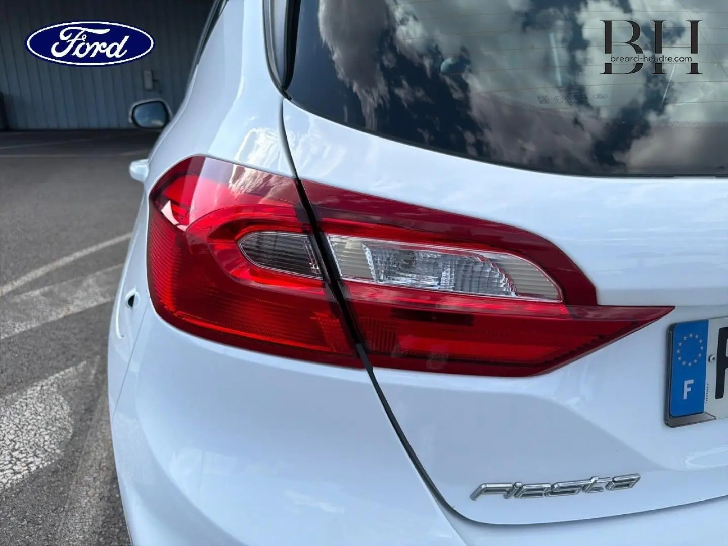 Gros plan sur le feu arrière droit d'une Ford Fiesta blanc glacier, avec le logo Fiesta visible sur le hayon.