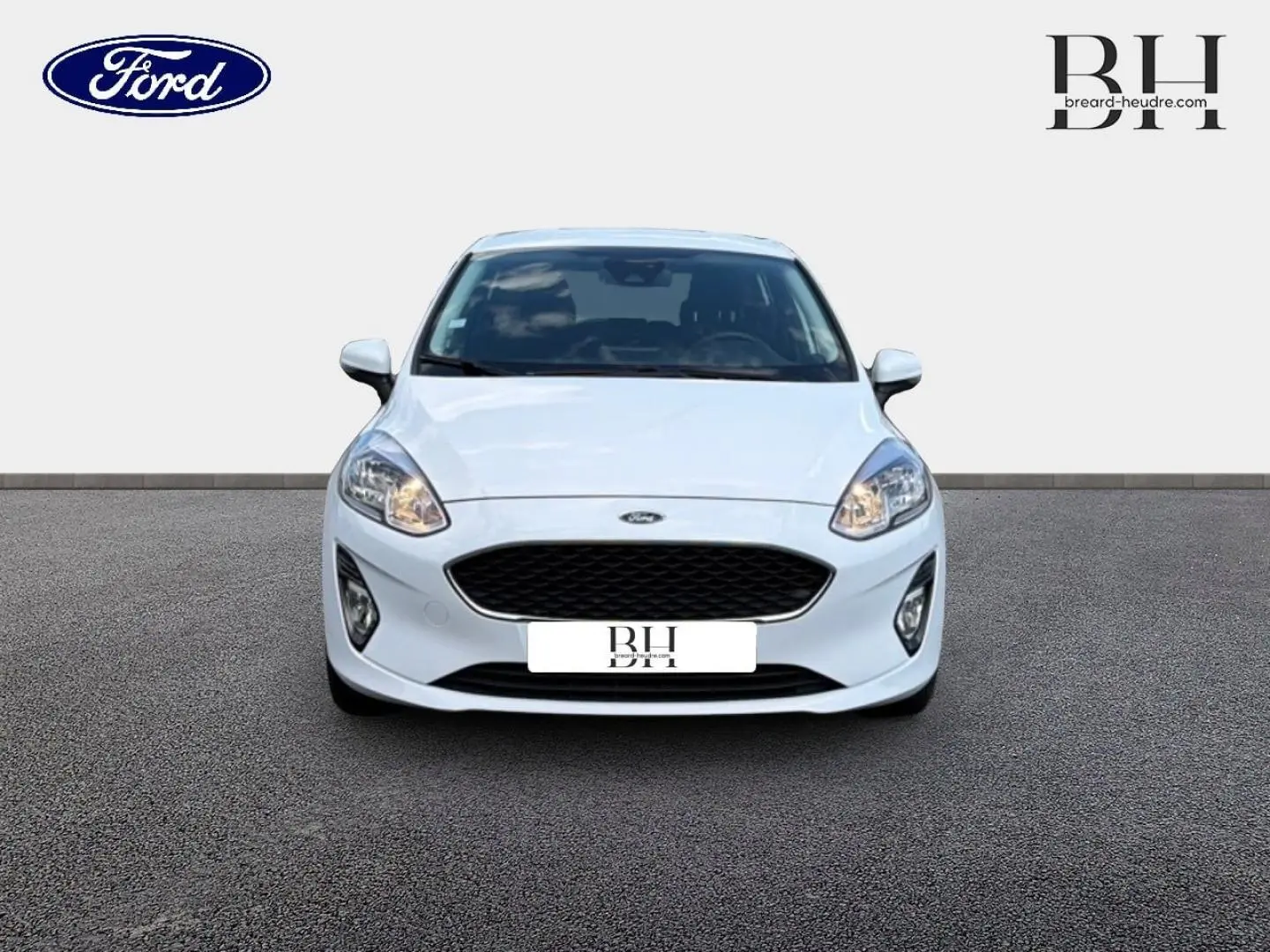 Vue frontale d'une Ford Fiesta blanche Glacier 2020 avec calandre noire et phares allumés sur fond neutre.