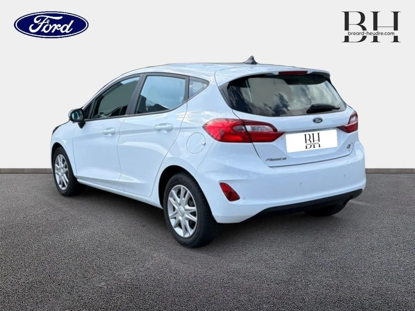 Ford Fiesta blanc glacier vue 3/4 arrière droit, avec feux arrière rouges et jantes argentées.