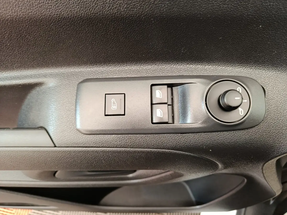 Gros plan sur les commandes de réglage des rétroviseurs et des vitres côté conducteur d'un Citroën Berlingo blanc 2022.