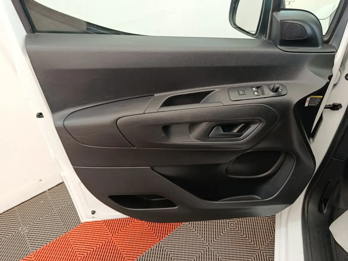 Vue rapprochée de la porte avant gauche noire intérieure du Citroën Berlingo blanc 2022 avec commandes électriques.
