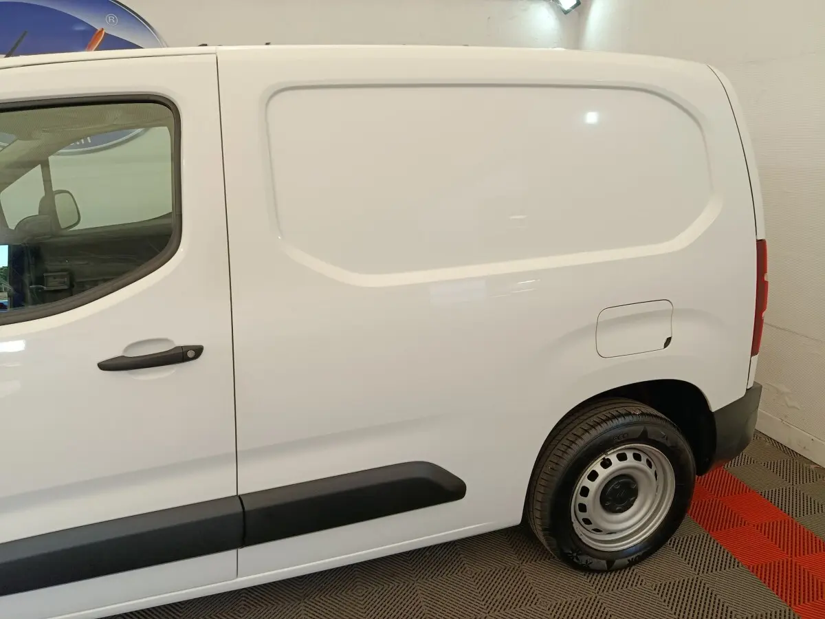 Vue latérale droite d’un utilitaire Citroën Berlingo blanc avec porte latérale pleine et jante acier.