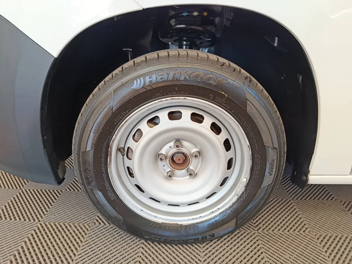 Gros plan sur la roue avant droite blanche d’un Citroën Berlingo blanc avec pneu Hankook visible.