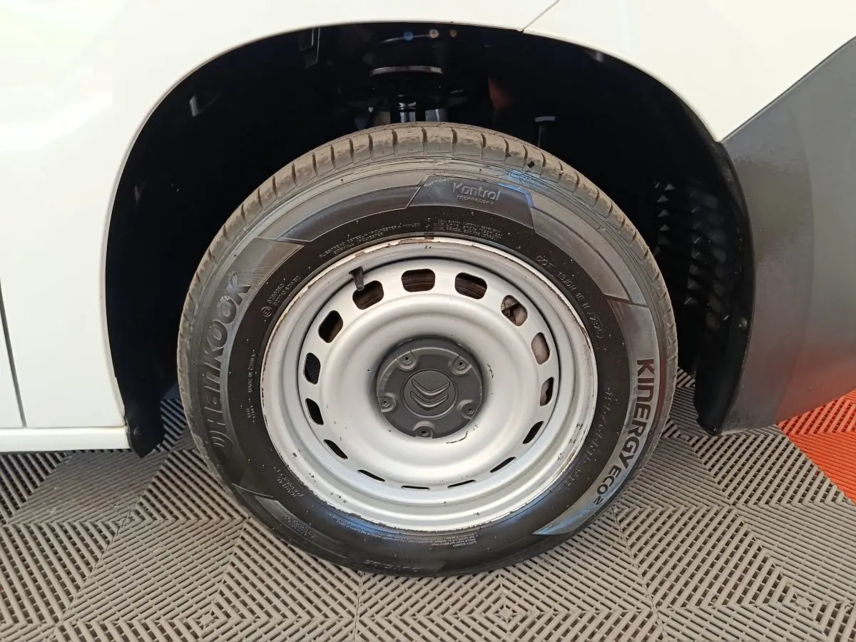 Gros plan sur la roue avant droite blanche en jante acier du Citroën Berlingo blanc, avec pneu Hankook visible.