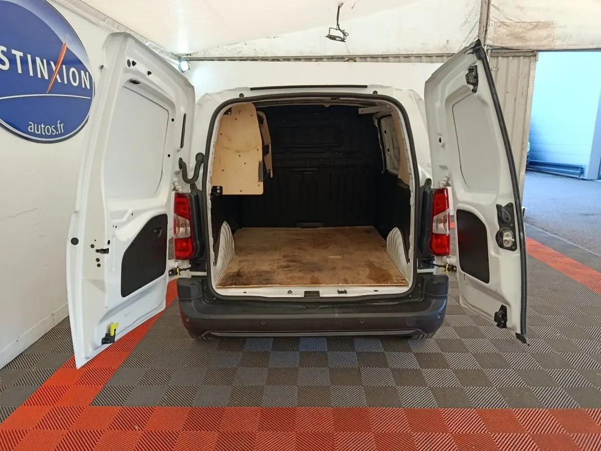 Vue arrière d’un Citroën Berlingo blanc 2022 avec portes arrière ouvertes montrant l’espace de chargement vide.