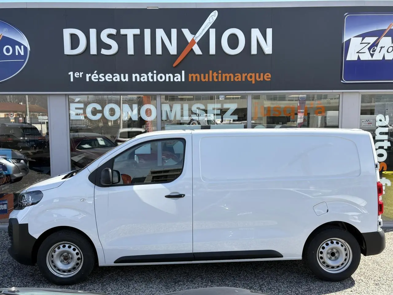 Vue de profil côté gauche d’un utilitaire Opel Vivaro blanc 2024 avec porte latérale coulissante et jantes acier.