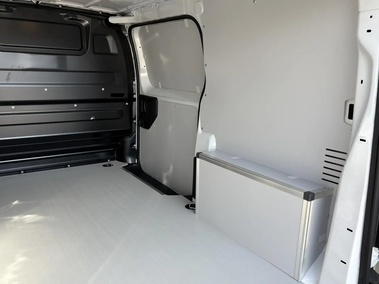 Intérieur arrière du fourgon Opel Vivaro blanc, vue côté droit montrant le plancher bois et habillage latéral en bois.