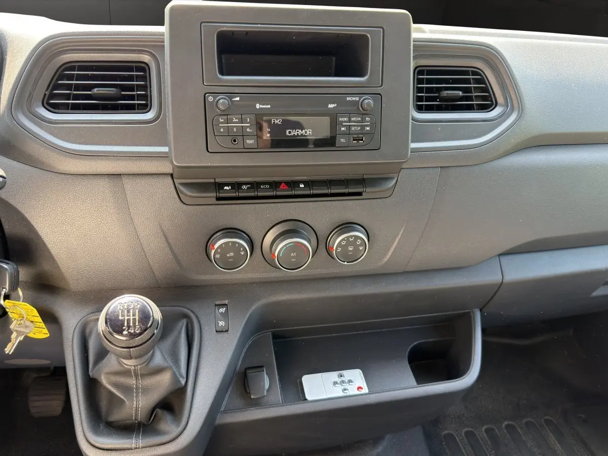 Vue rapprochée de la console centrale noire du Renault Master 2024 avec levier de vitesse manuel et commandes climatisation.