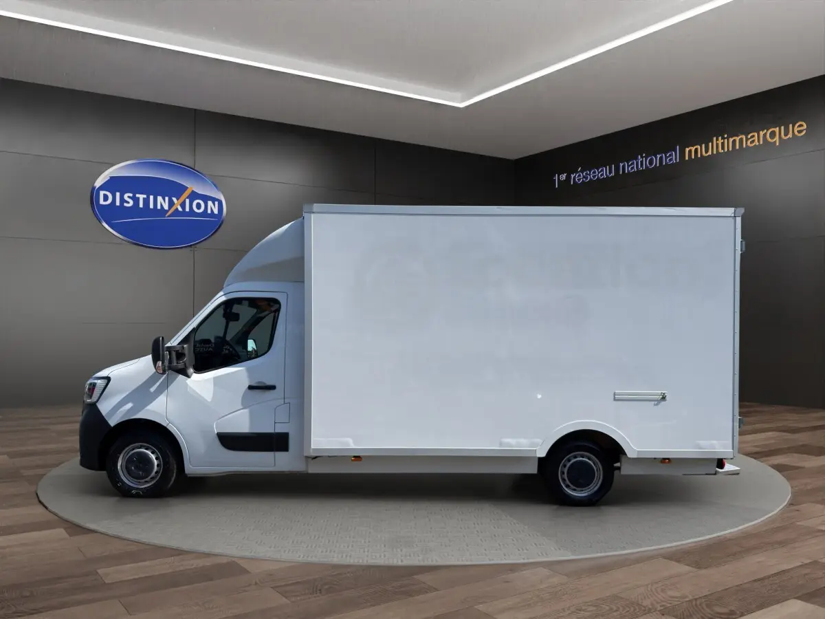Vue de profil côté gauche d’un Renault Master blanc 2024 avec caisse utilitaire volumineuse en intérieur showroom.