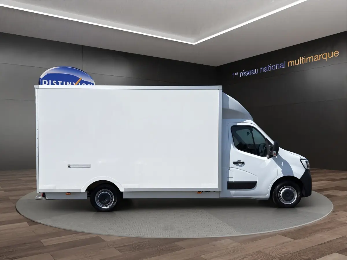 Vue de profil côté droit d’un utilitaire blanc Renault Master PHC TRAC 2024 avec caisse 20m3 dans un showroom.