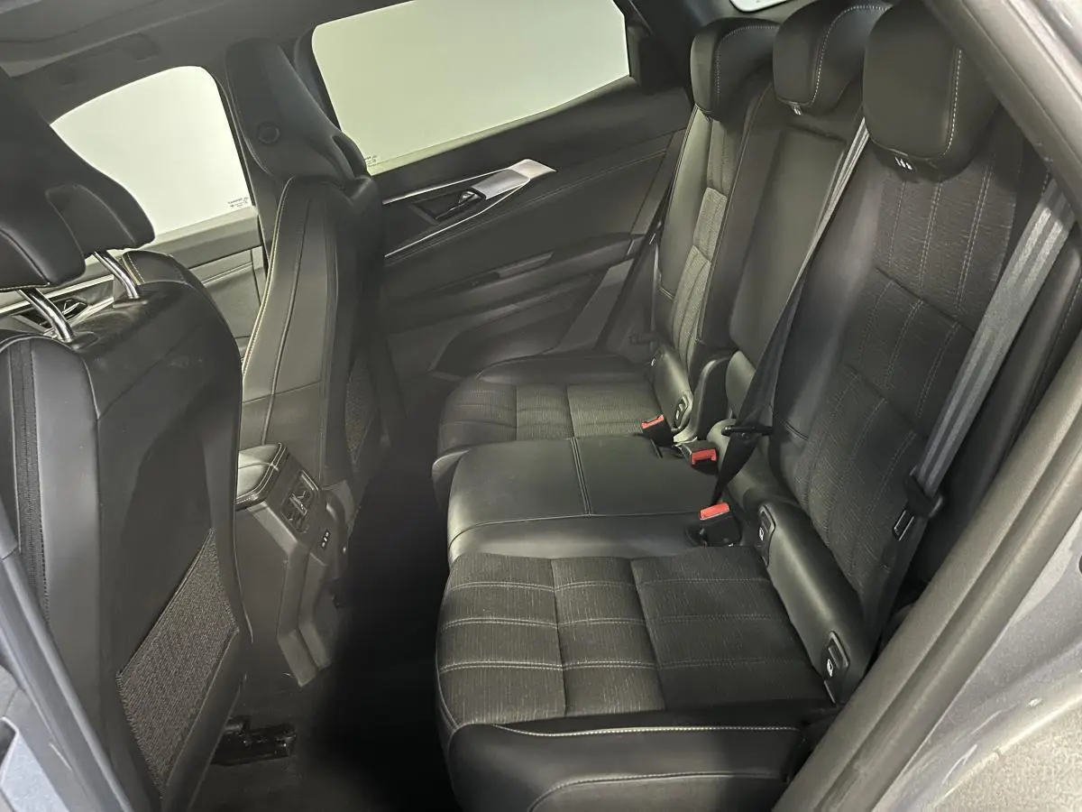 Vue côté droit de la banquette arrière noire mixte cuir et tissu du Renault Austral gris 2024 avec surpiqûres or.