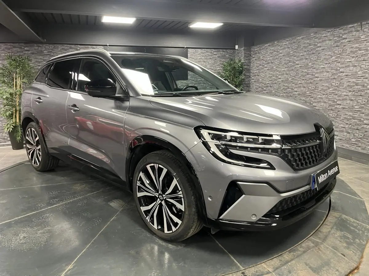 Renault Austral gris schiste en 3/4 avant droit, avec jantes alliage 20 pouces et toit panoramique fixe.