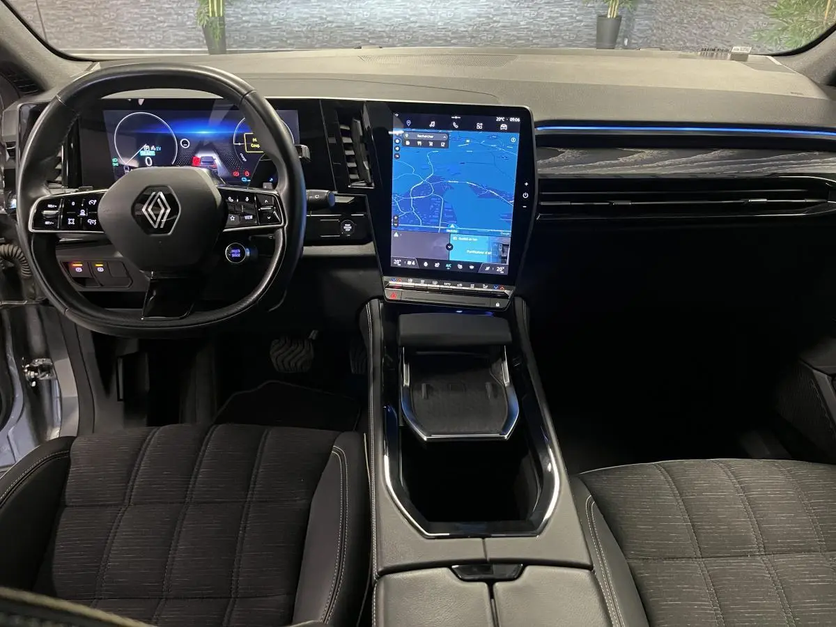 Vue intérieure avant du Renault Austral gris avec tableau de bord numérique et écran tactile vertical central.