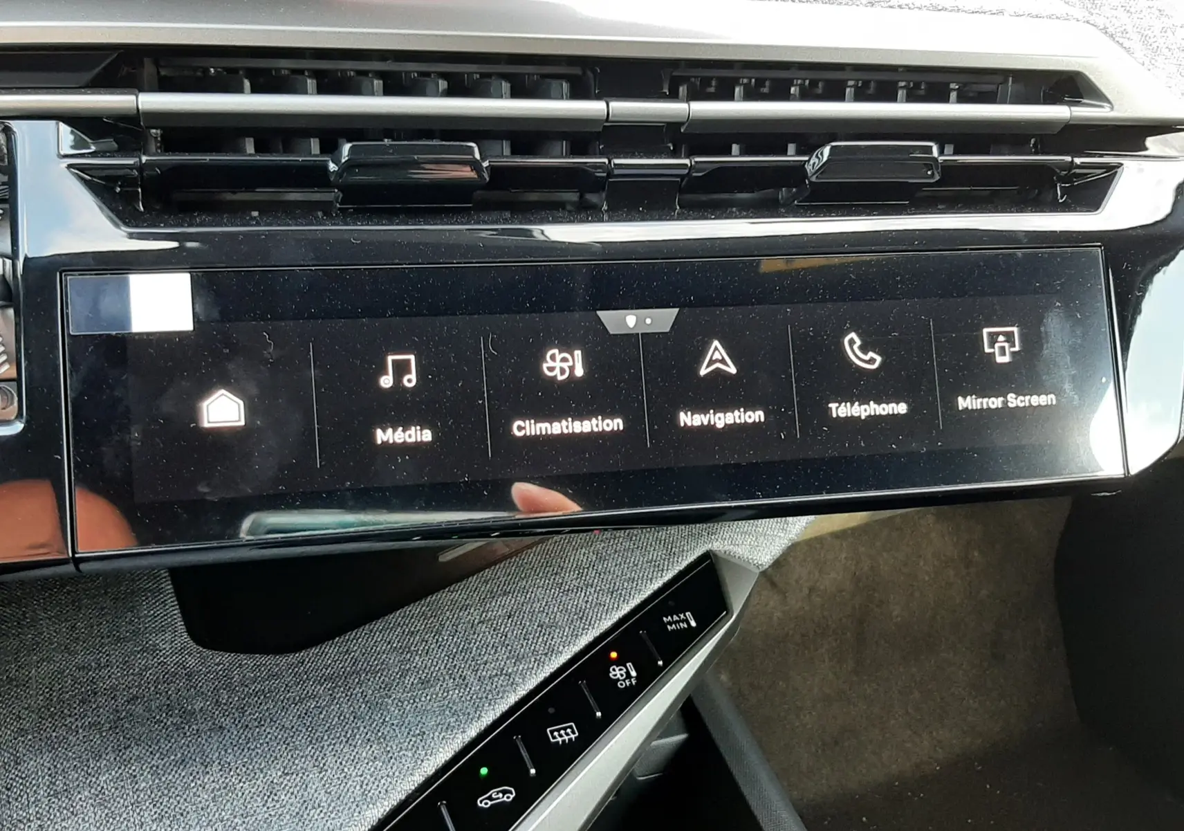 Vue rapprochée de la console centrale tactile noire du Peugeot 5008 bleu Ingaro, affichant les commandes multimédia et climatisation.
