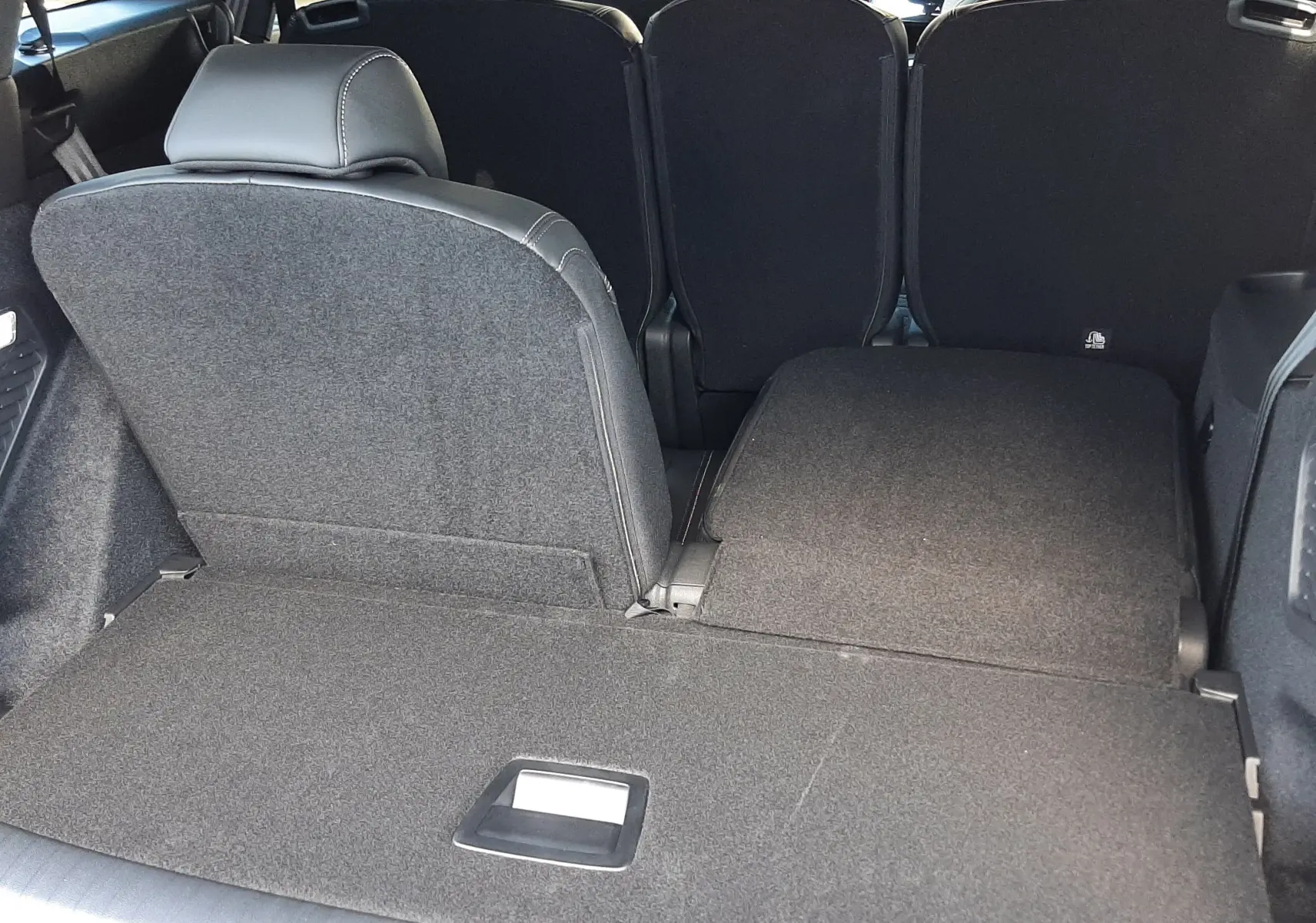 Vue arrière du coffre du Peugeot 5008 bleu Ingaro, siège arrière droit rabattue, intérieur spacieux et modulable.