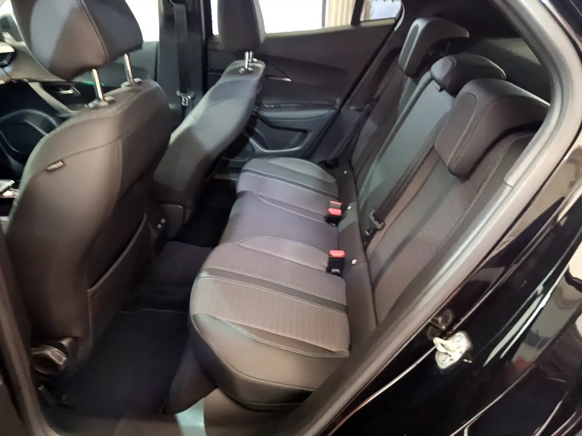 Vue côté droit de l'habitacle arrière du Peugeot 2008 noir, montrant les sièges en cuir et tissu avec appuie-têtes.
