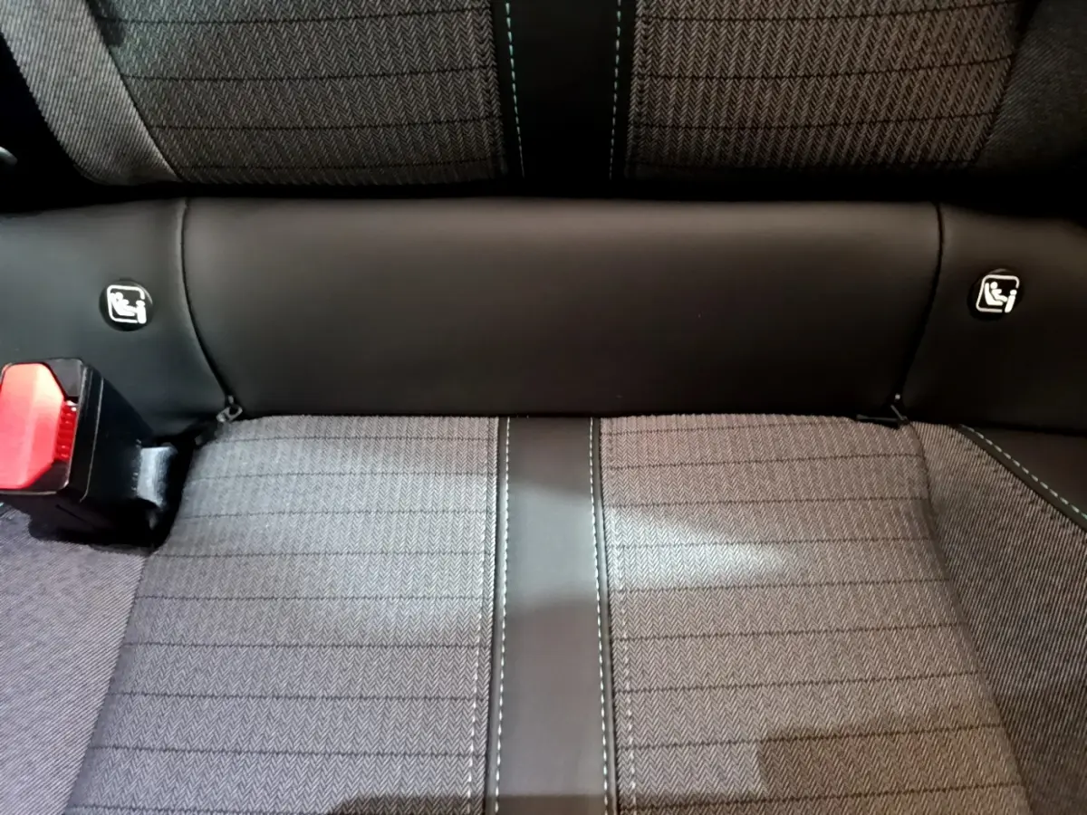Gros plan sur la banquette arrière grise et noire du Peugeot 2008, avec fixations Isofix visibles et ceinture rouge.