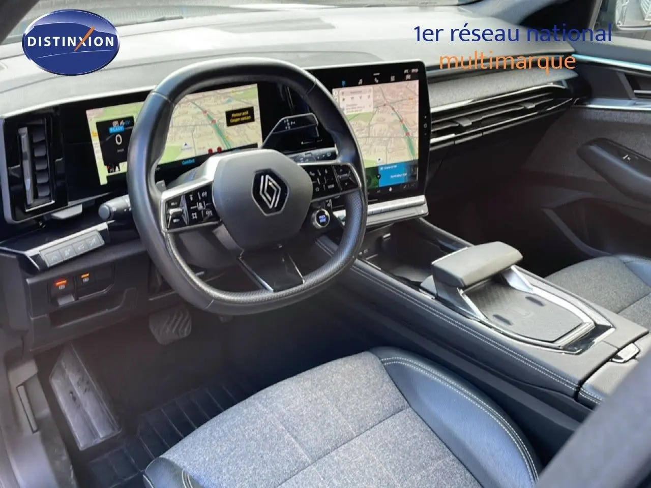 Vue intérieure côté conducteur du Renault Espace 2024, volant multifonction et grand écran tactile central visibles.