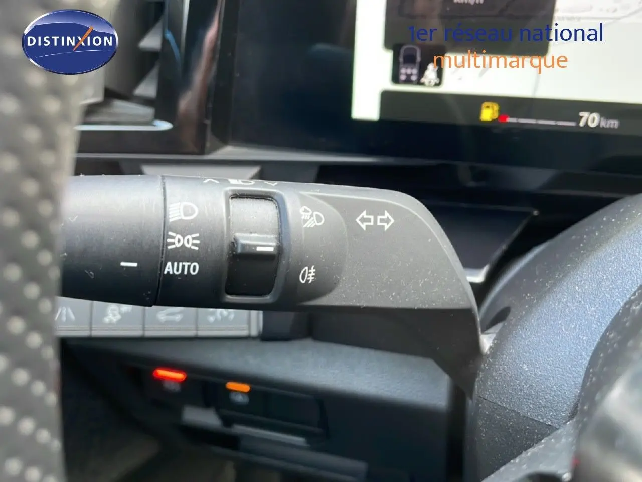 Gros plan sur la commande des feux et clignotants à gauche du volant dans un Renault Espace gris schiste 2024.