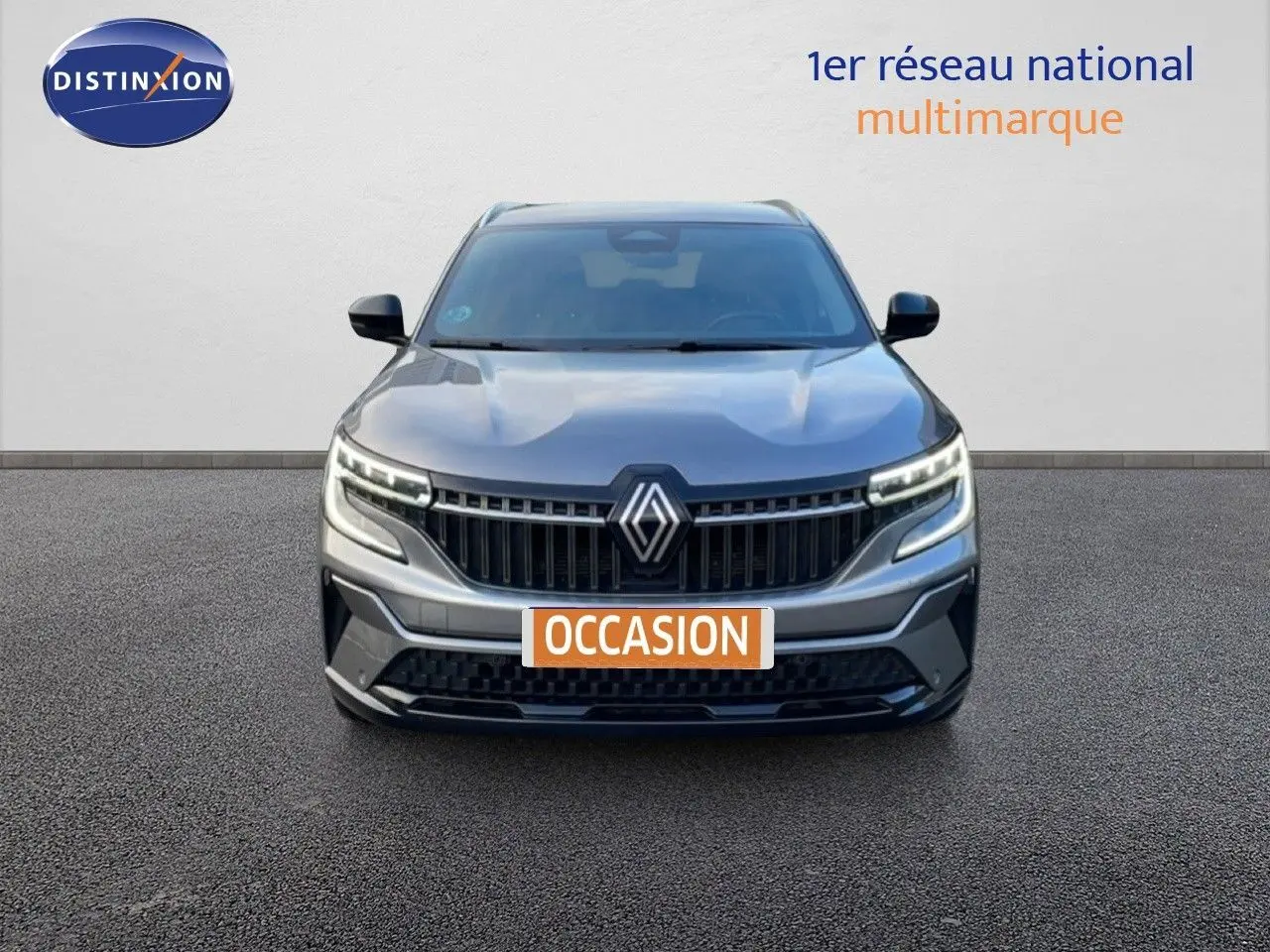 Vue frontale d'un Renault Espace gris schiste métal 2024 avec calandre marquée et feux LED allumés.