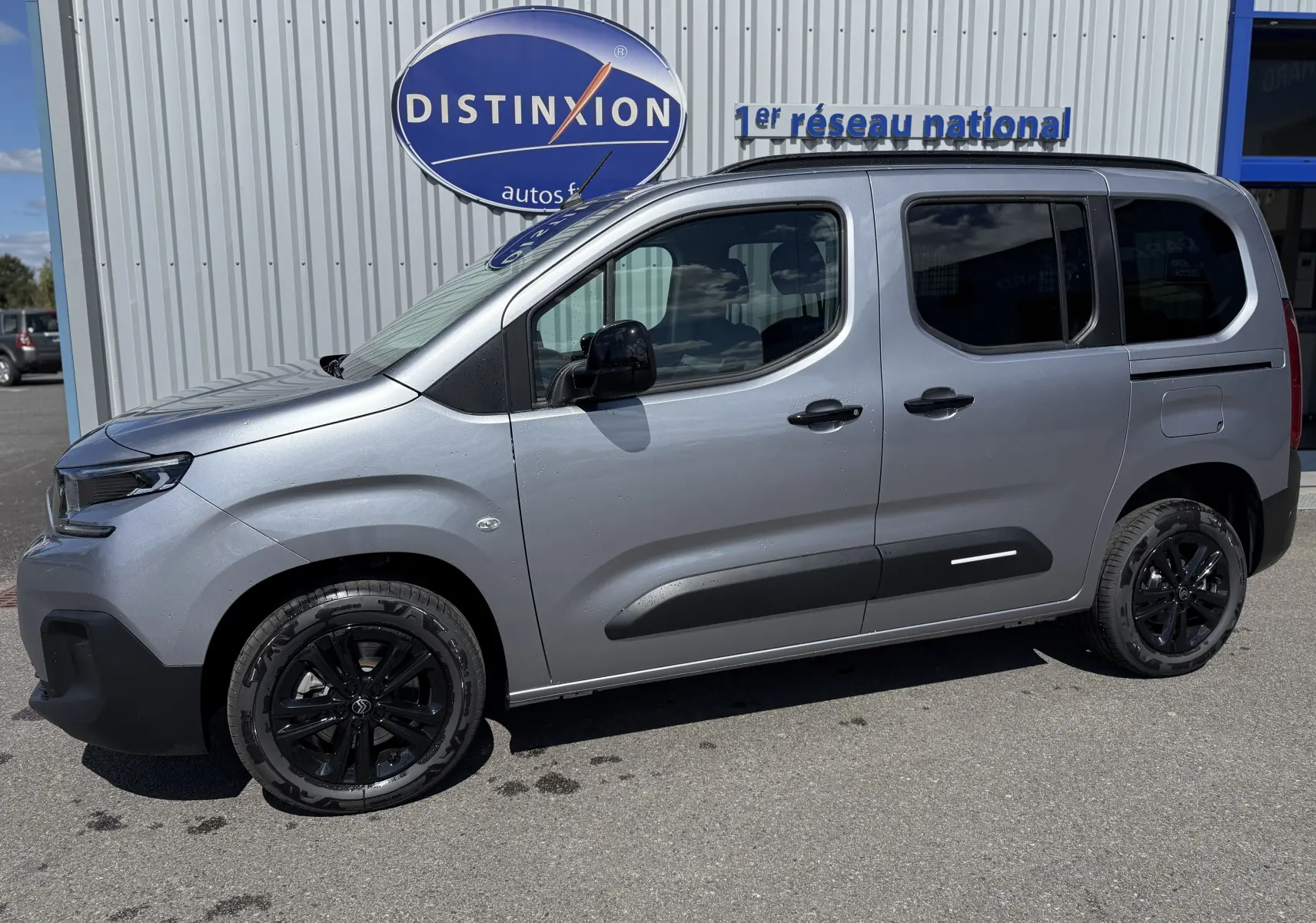 Vue latérale droite d'un Citroën Berlingo gris Artense métal 2026 avec jantes noires et vitres teintées.