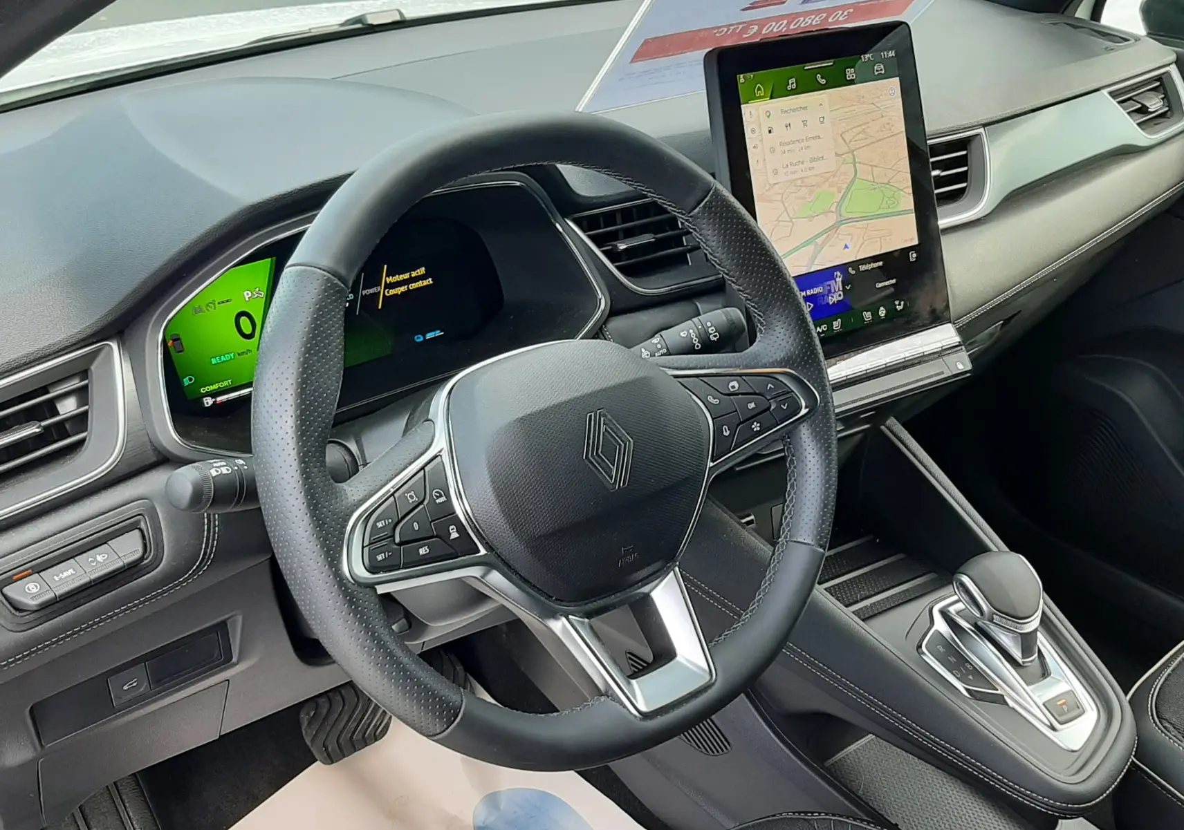 Vue intérieure du poste de conduite du Renault Symbioz blanc nacré 2025, avec volant multifonction et écran tactile central vertical.