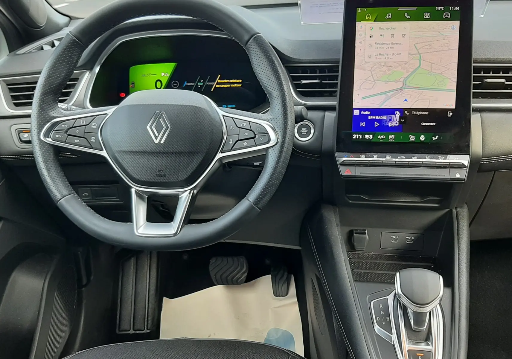 Vue intérieure centrée sur le volant et la console centrale avec écran tactile du Renault Symbioz blanc nacré 2025.