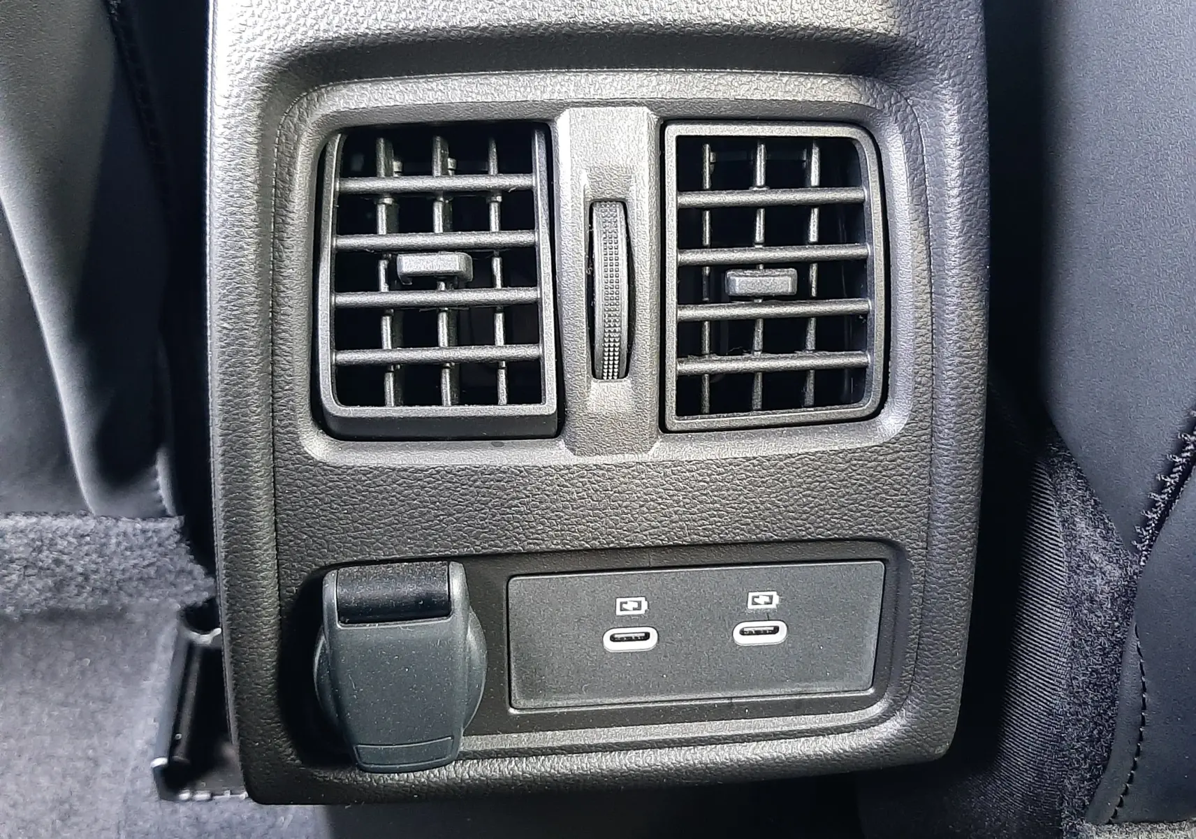 Vue rapprochée des aérateurs arrière et des ports USB-C noirs sur la console centrale du Renault Symbioz blanc nacré.