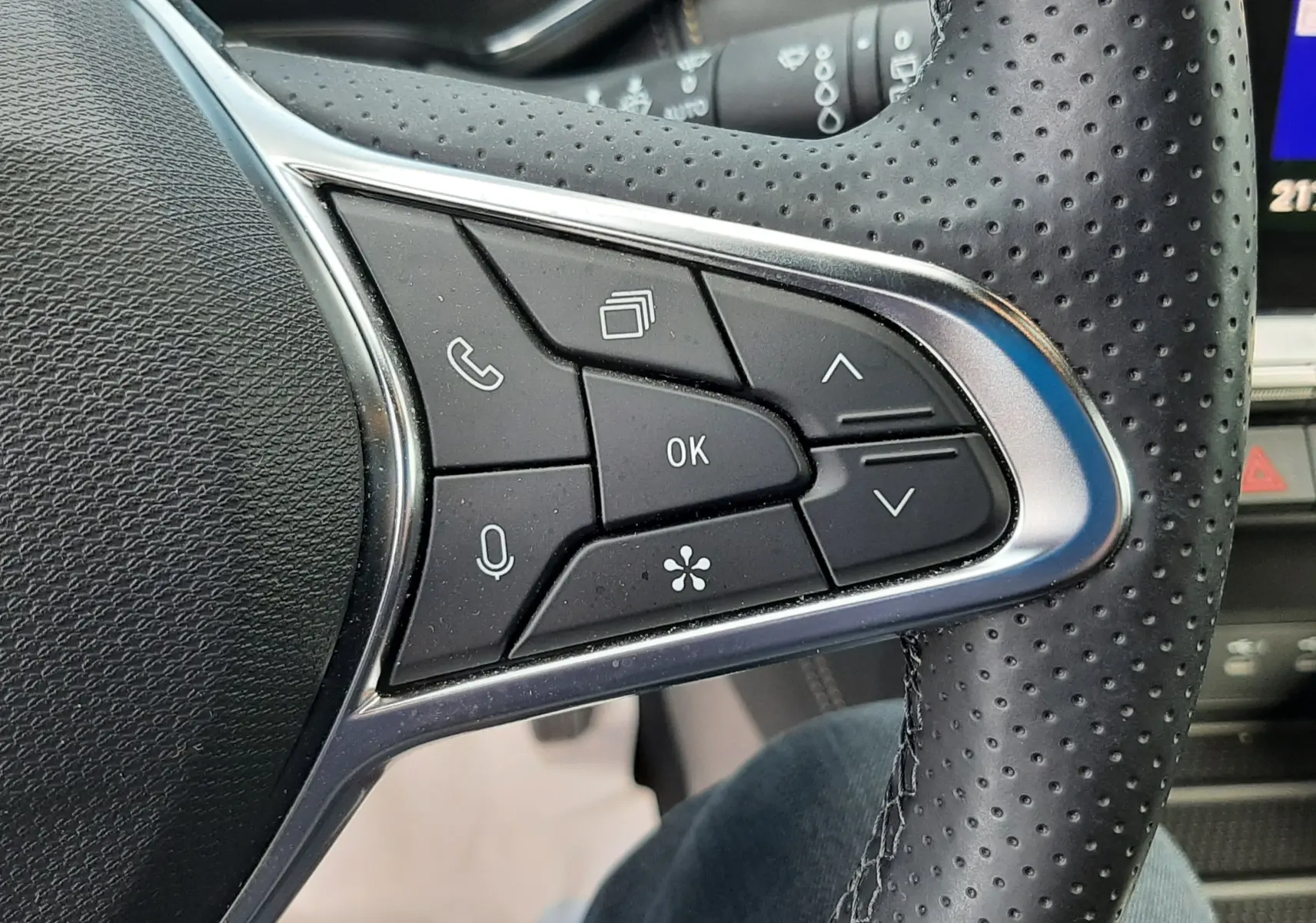 Gros plan sur les commandes multifonctions à droite du volant en cuir perforé noir du Renault Symbioz E-Tech Full Hybrid 2025.