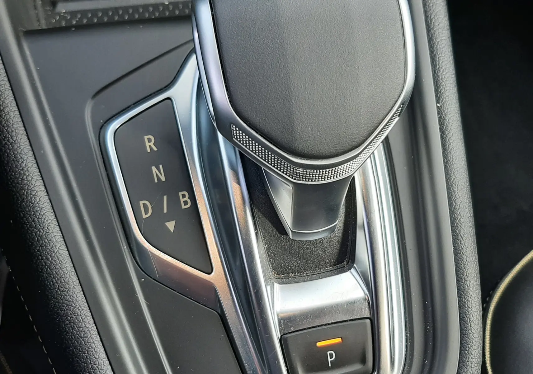 Le levier de vitesses automatique noir et chrome vu de dessus dans l'habitacle du Renault Symbioz blanc nacré.